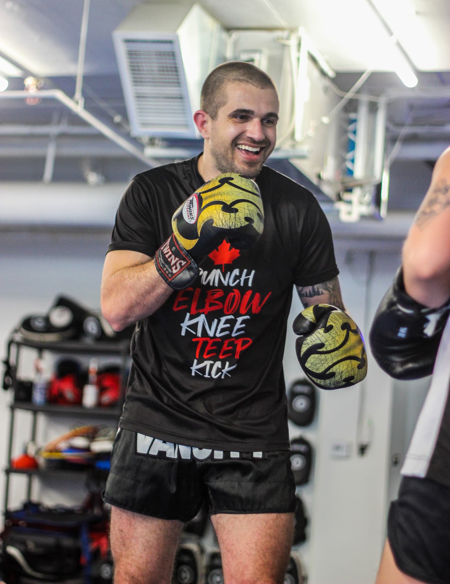 Kru Pedro, Muay Thai coach at Dream Fighters Canada, smiling in gloves at PTT Vancity