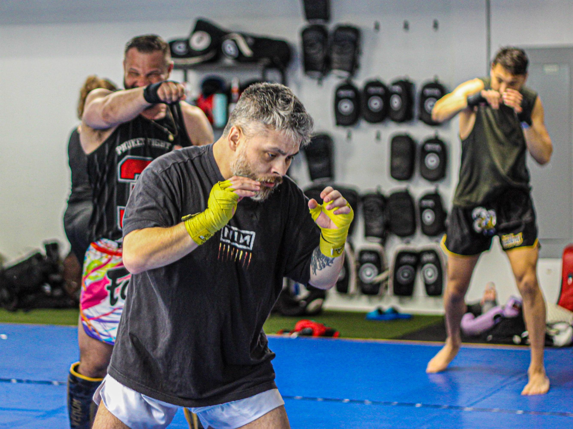Students shadow boxing on the mats during warm-up