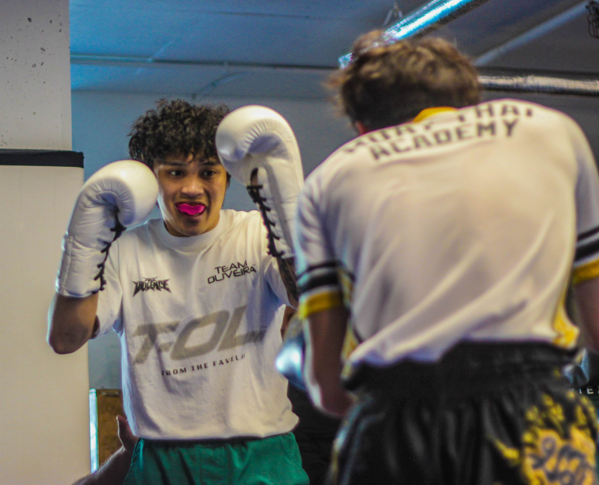 Students working controlled partner rounds in the gym